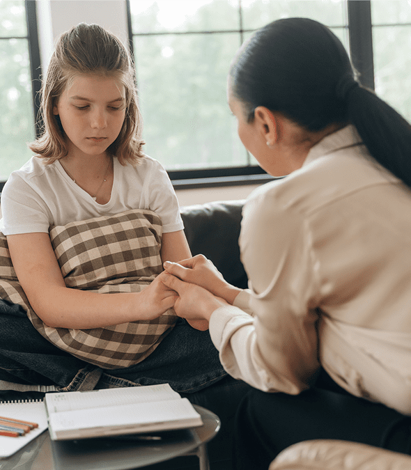 Therapist comforting young girl in session