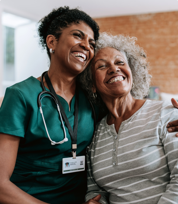 Smiling nurse embraces elderly woman with warmth and care.