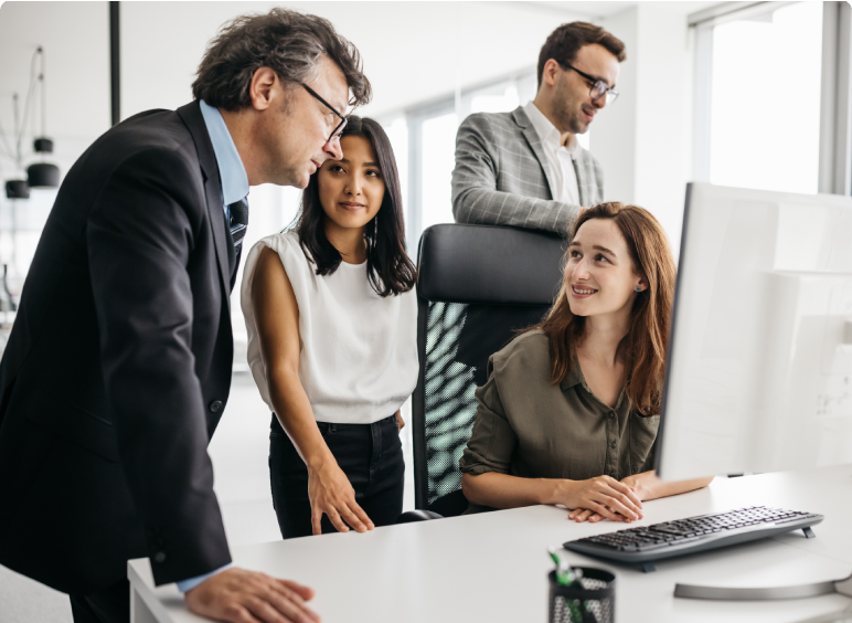 Business team collaborating around a computer in an office.