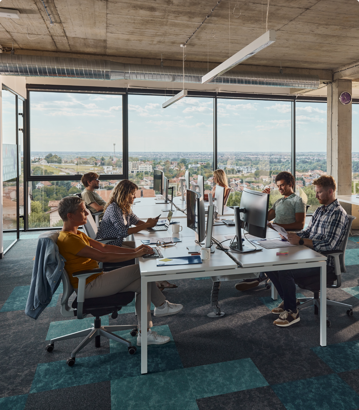 People working together in a modern office with a city view.