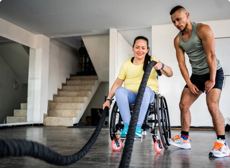 Woman in wheelchair using battle ropes